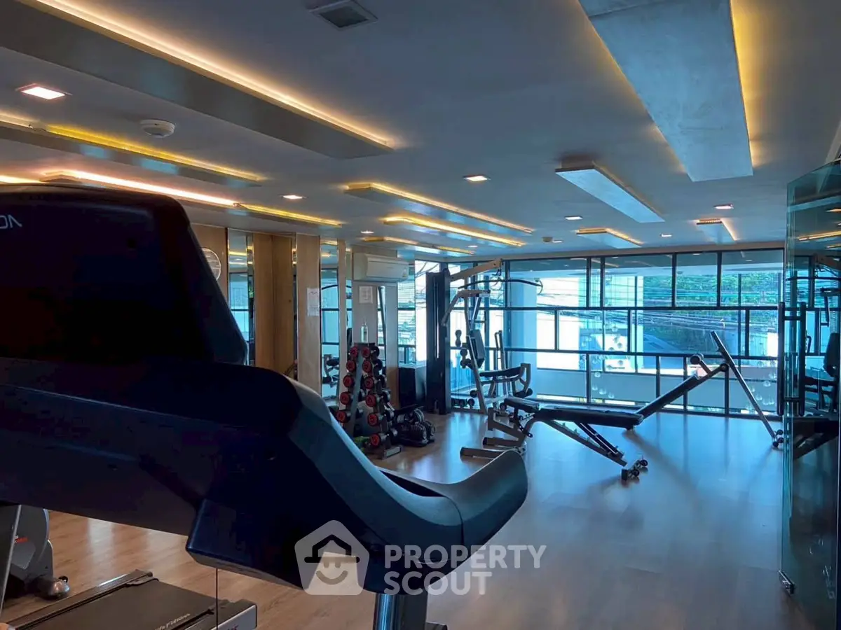 Modern gym with state-of-the-art equipment and large windows for natural light.