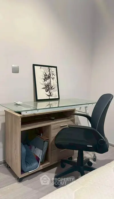 Modern study area with glass desk and ergonomic chair in a stylish home office.