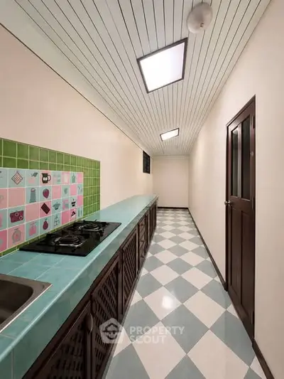 Charming retro kitchen with colorful tiles and gas stove in a narrow layout
