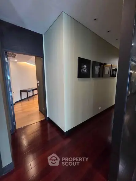 Elegant hallway with dark wood flooring and modern art decor