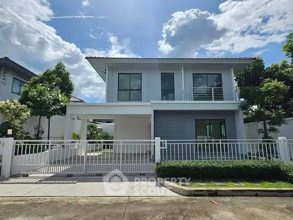 Modern two-story house with sleek design and spacious driveway in a serene neighborhood.