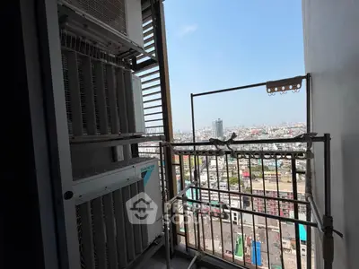 High-rise balcony with cityscape view and air conditioning units.
