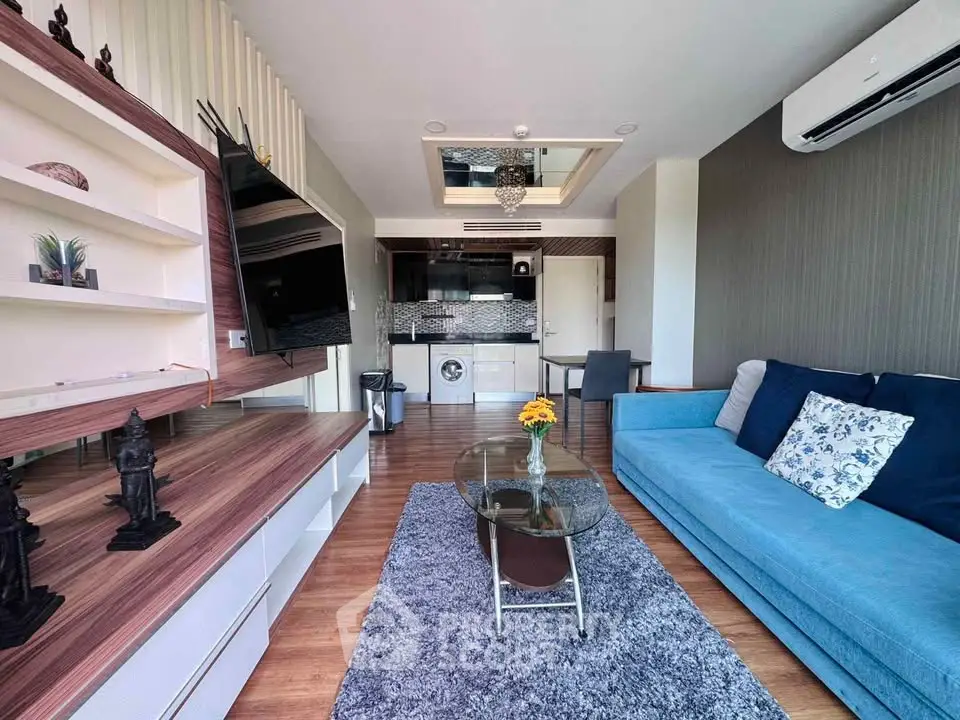 Modern living room with stylish decor, open kitchen, and cozy seating area in a contemporary apartment.