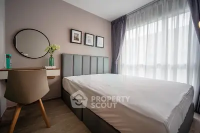 Modern bedroom with stylish decor, large window, and cozy ambiance in a contemporary apartment.