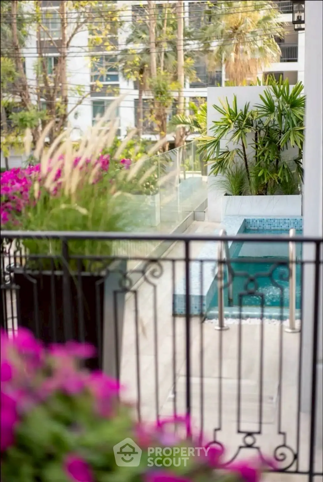 Luxurious poolside view with lush greenery and elegant railing, perfect for relaxation and leisure.