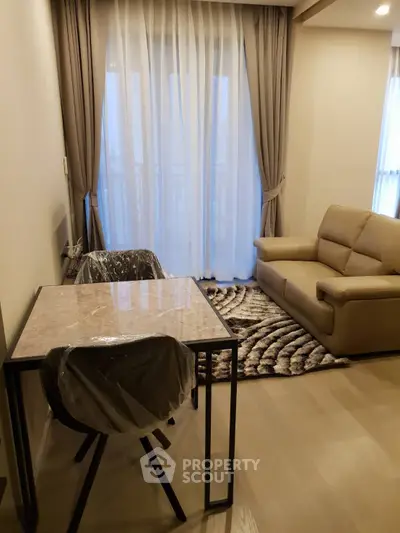 Modern living room with elegant furniture and large window, perfect for cozy gatherings.