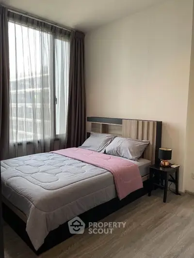 Modern bedroom with large window and stylish decor in a contemporary apartment.