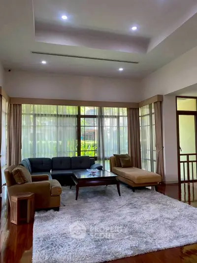 Spacious living room with elegant furniture and large windows offering natural light.