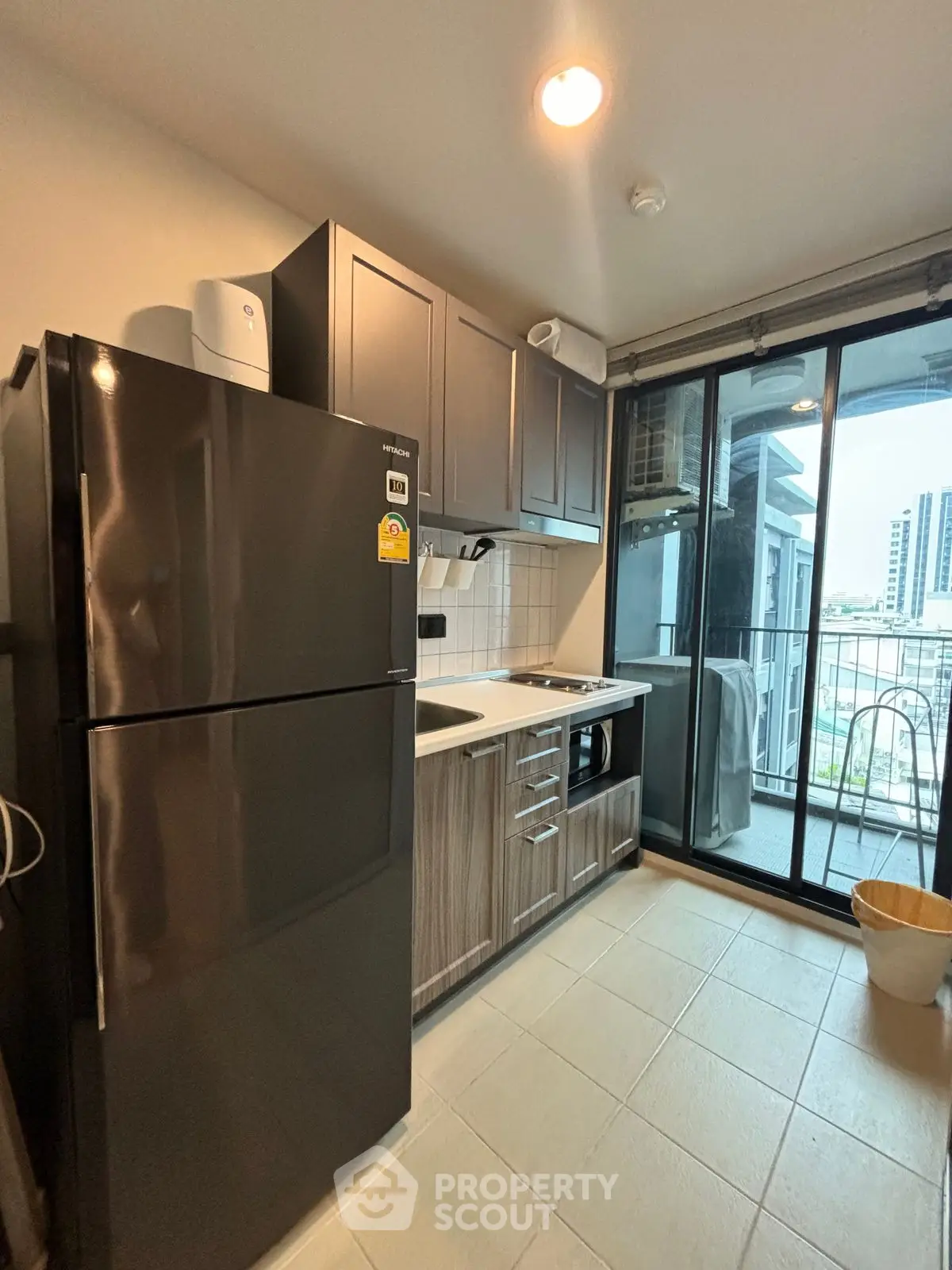 Modern kitchen with sleek appliances and balcony view in urban apartment