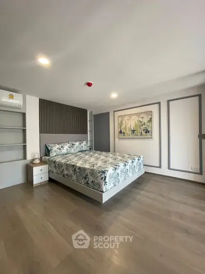 Spacious modern bedroom with stylish decor and ample natural light