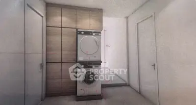 Modern laundry area with stacked washer and dryer in sleek apartment interior.