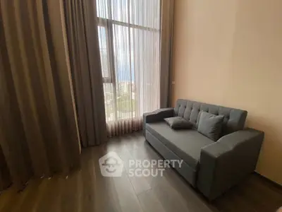 Cozy living room with modern sofa and large window offering city view