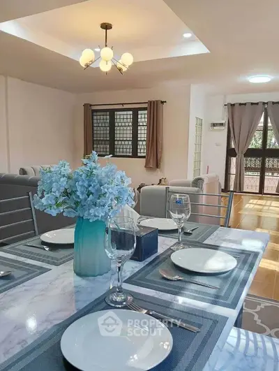 Elegant dining area with modern decor and natural light in a spacious living room.