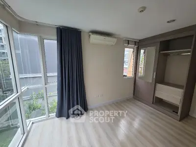 Spacious corner unit bedroom with large windows and built-in closet