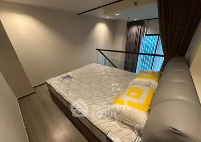 Modern bedroom with stylish decor and large window offering city view, perfect for urban living.