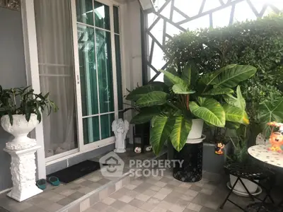 Charming balcony with lush greenery and elegant decor, perfect for relaxation.