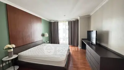 Spacious bedroom with modern decor and large window for natural light.