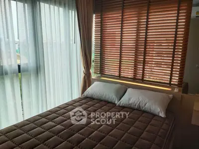 Cozy bedroom with large windows and stylish blinds offering natural light and comfort.