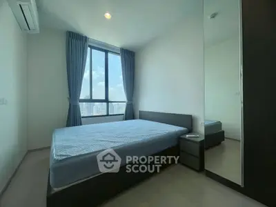 Modern bedroom with large window and city view, featuring minimalist design and ample natural light.