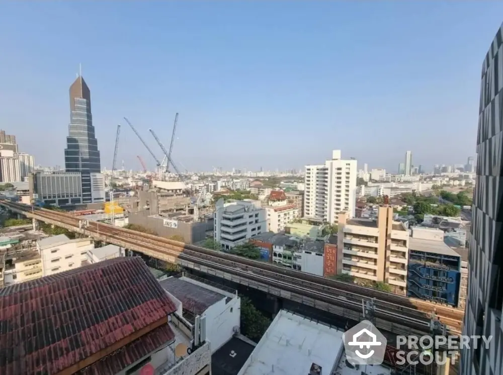 Stunning cityscape view from high-rise apartment with skyline and railway in vibrant urban setting.