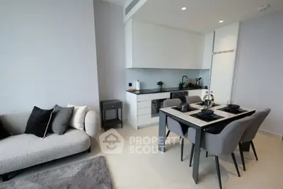 Modern open-plan living room and kitchen with sleek furniture and dining area.