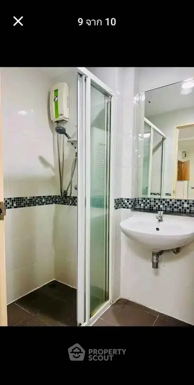 Modern bathroom with shower and sleek white sink in a stylish apartment.