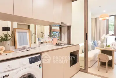 Modern kitchen with washing machine and cozy living area in open layout apartment