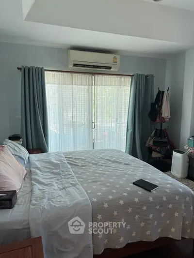 Cozy bedroom with star-patterned bedding and balcony access