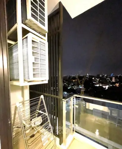 Stylish balcony with city view and modern air conditioning units at night