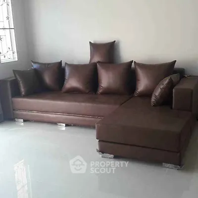Modern brown leather sofa in a spacious living room with glossy tiled floor.