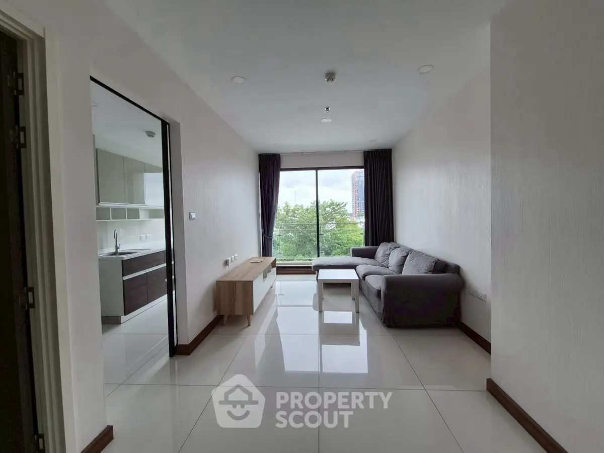 Modern living room with large window and stylish furniture in a high-rise apartment.