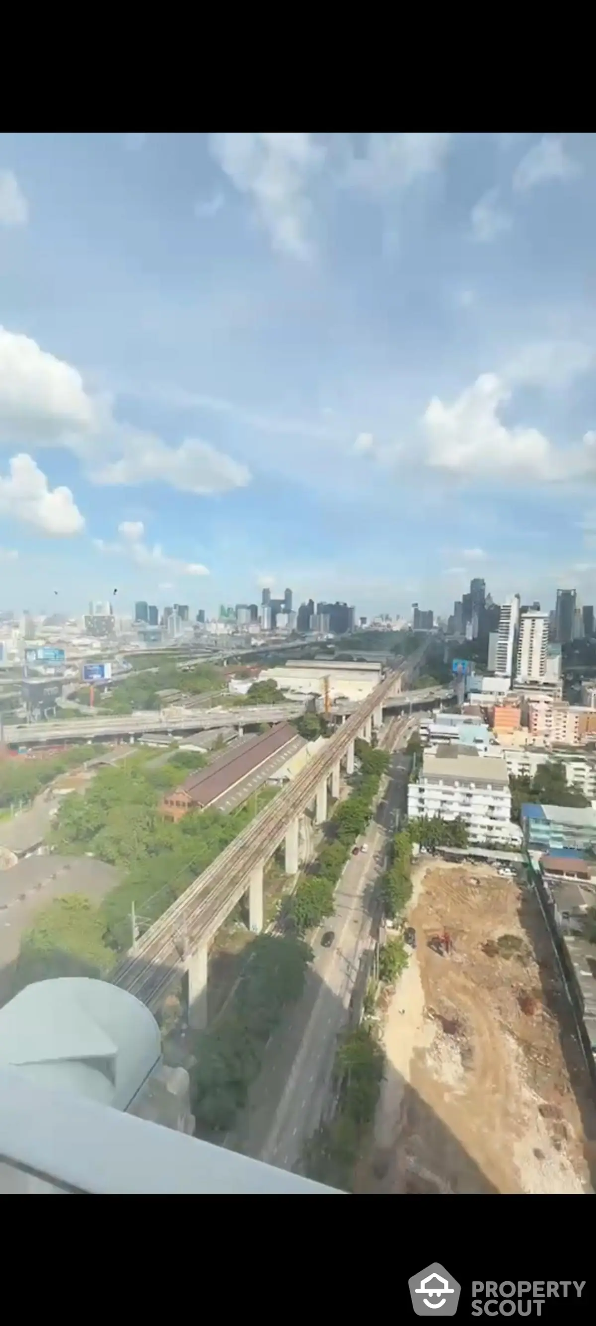 Stunning cityscape view from high-rise building showcasing urban skyline and transportation infrastructure.