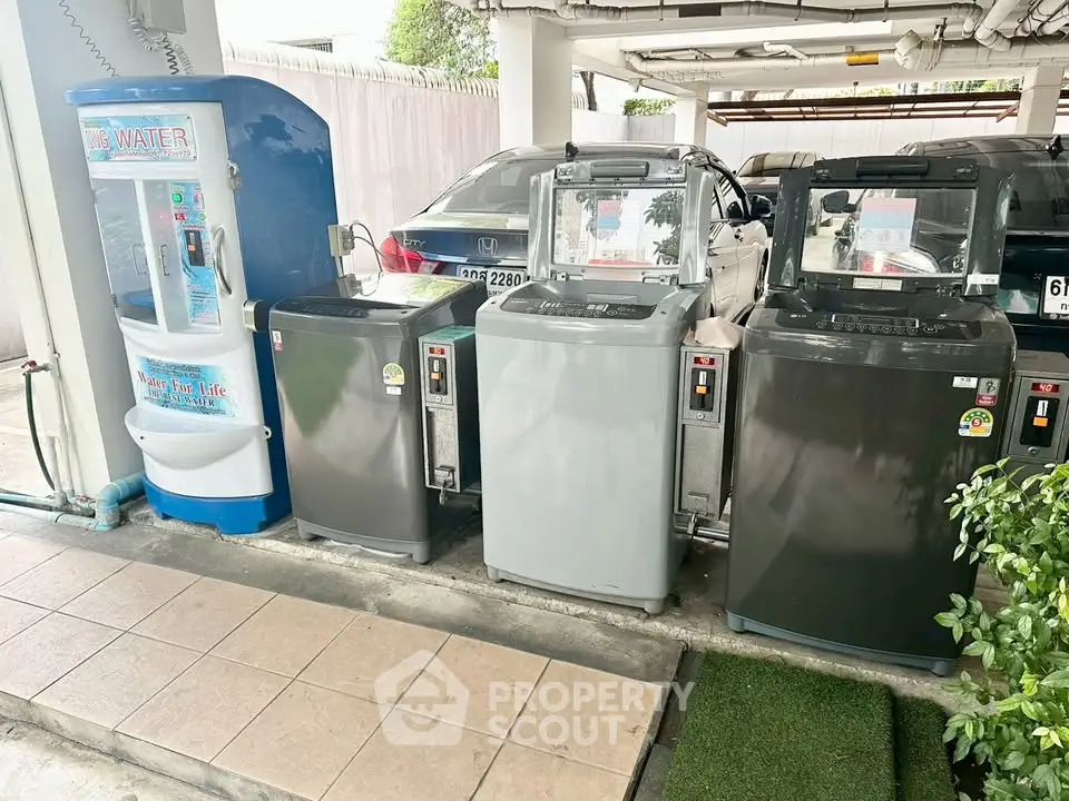 Convenient shared laundry area with washing machines and water dispenser in residential building.
