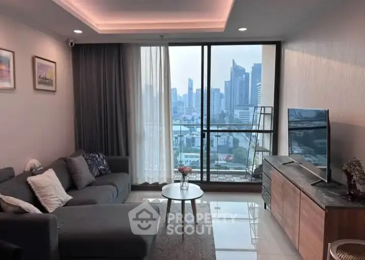 Modern living room with city view, cozy sofa, and sleek TV setup.