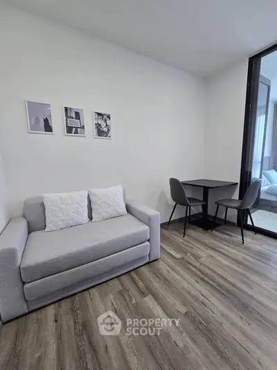 Modern living room with sleek gray sofa and stylish dining area, perfect for cozy urban living.