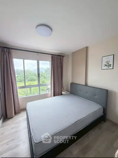 Spacious bedroom with large window offering scenic views and modern decor.