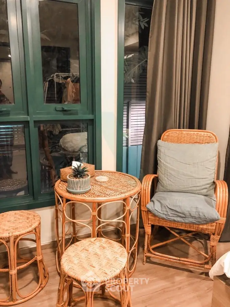 Cozy corner with wicker furniture and large window in stylish apartment.