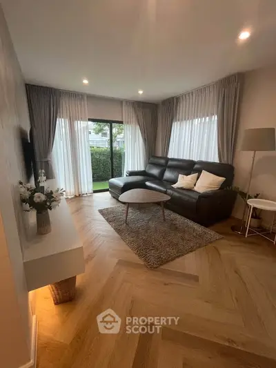 Modern living room with elegant decor and large windows for natural light.