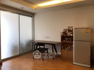 Cozy dining area with modern table and fridge in a well-lit room