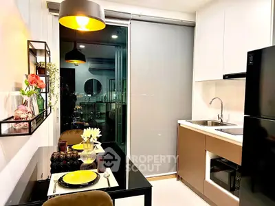 Modern kitchen with sleek design, featuring a dining area and large refrigerator, perfect for urban living.