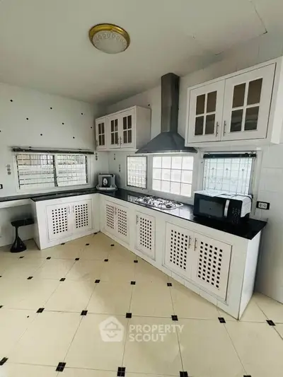 Modern kitchen with sleek cabinetry and gas stove in a bright, airy space.
