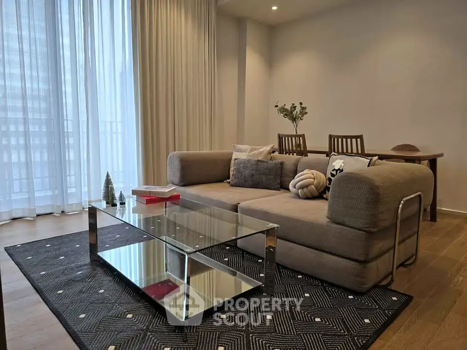 Modern living room with stylish sofa, glass coffee table, and elegant decor in a bright apartment.