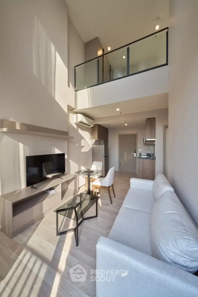 Modern loft-style living room with high ceilings and natural light