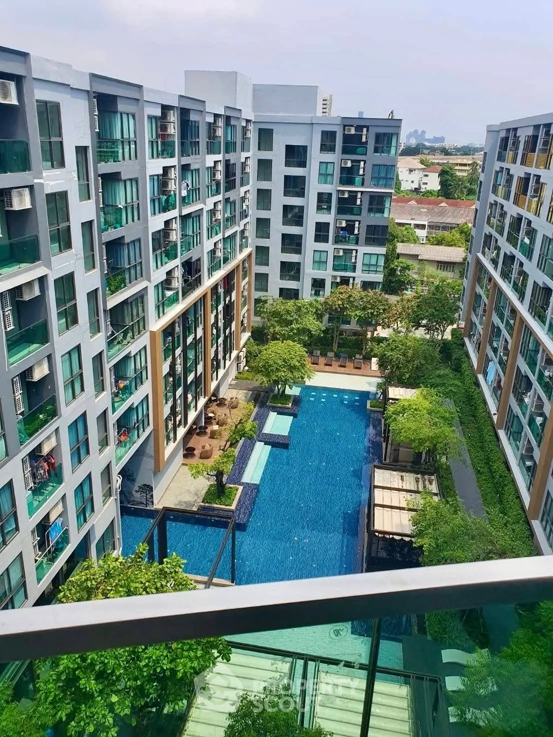 Modern apartment complex with a stunning pool view and lush greenery.