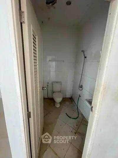 Compact bathroom with basic fixtures and tiled walls, ideal for small spaces.