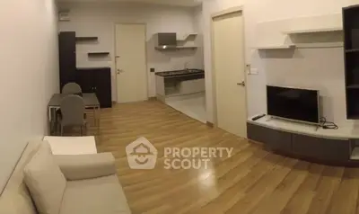 Modern open-plan living room with sleek kitchen and cozy seating area, perfect for urban living.