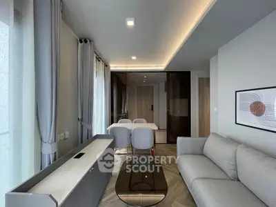 Modern living room with elegant decor and dining area, featuring sleek furniture and ambient lighting.