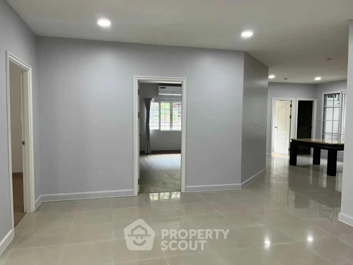 Spacious modern interior with sleek tile flooring and ample natural light, perfect for versatile living arrangements.