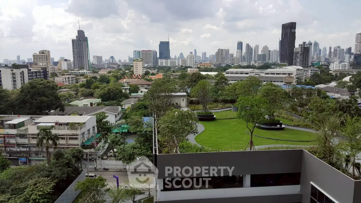 Stunning cityscape view from a high-rise building with lush green rooftop garden.
