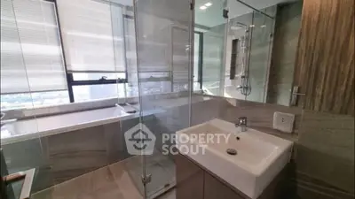 Luxurious bathroom with glass shower and city view, featuring modern sink and bathtub.